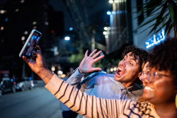 istock Friends taking a selfie or filming using mobile phone outdoors 1417765702