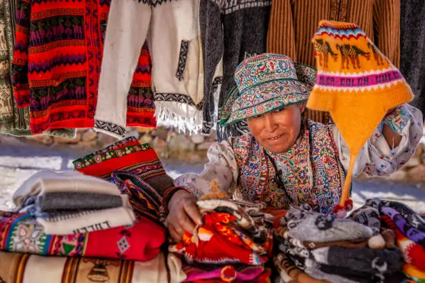 Peruvian woman selling souvenirs in her shop near Colca Canyon, Peru. Colca Canyon is a canyon of the Colca River in southern Peru. It is located about 100 miles (160 kilometers) northwest of Arequipa.