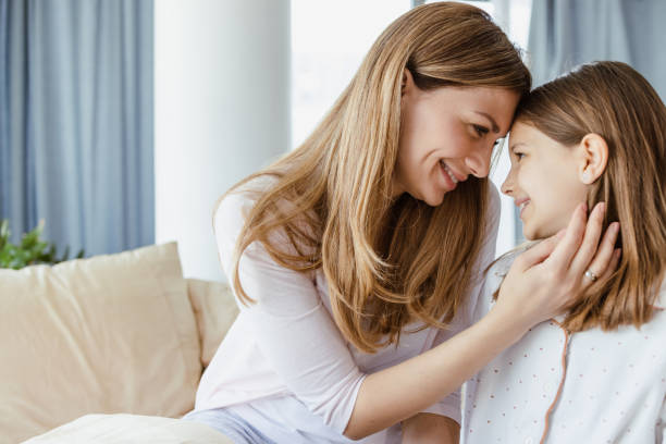 istock Mother cuddling daughter in the morning 1417773059
