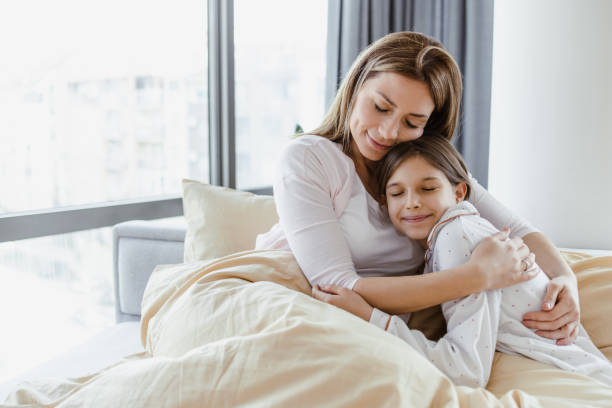 istock Affectionate mother with her daughter in bed 1417773733