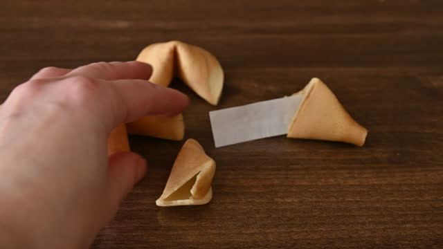 Person takes fortune cookie from the table