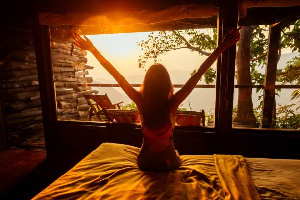 Young woman on f the house in the beautiful forest panoramic windows eco hotel in the jungle stock photo