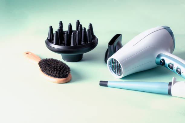 istock Ionic hairdryer with diffusers , natural wood brush  and curling iron on colorful background for hair care and styling concept. 1417781742