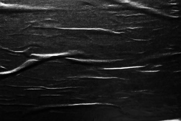 istock Black crumpled and creased paper poster texture background 1417782689