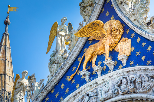 St Mark Basilica facade detail, with golden lion and angels, Venice, Italy