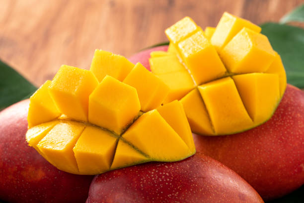 istock Mango. Fresh mango fruit with leaves over dark wooden table background. 1417819849