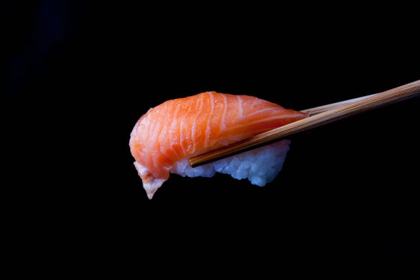 istock A Salmon sushi being held by wooden chopsticks 1417821765