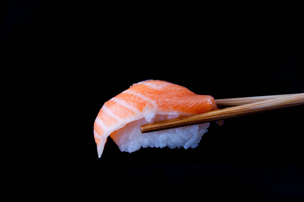 istock Salmon sushi by wooden chopsticks 1417821776