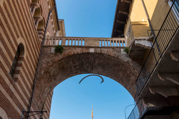 łuk tortur między dwoma starymi budynkami w weronie we włoszech - torre dei lamberti zdjęcia i obrazy z banku zdjęć