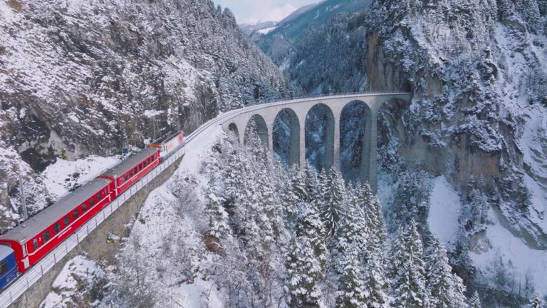 Landwasser Viaduct with Glacier and Bernina express in switzerland snow winter.