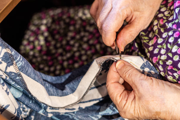 istock Elderly woman's hands cutting threads on clothes with a scissor 1417830307