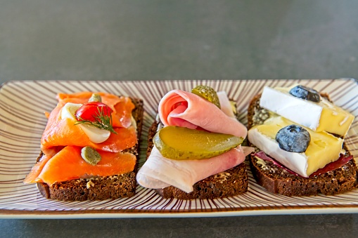 Traditional Finnish archipelago bread served three different way. With cold smoked salmon, with mortadella and pickled cucumber and with brie cheese and blueberry.