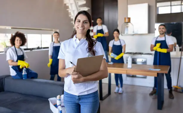 Portrait of a Latin American business woman leading a group of professional cleaners