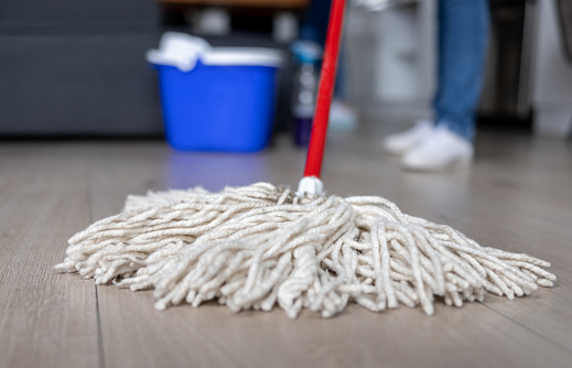 Close-up on a cleaner mopping a hardwood floor - housework concepts
