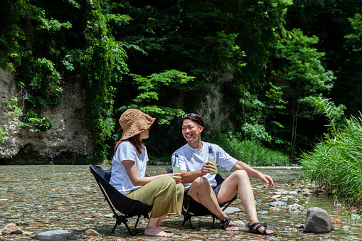 Man and woman sit and talk at river