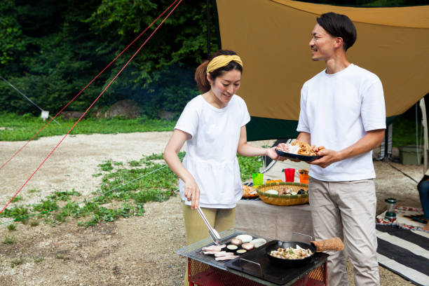 istock Young couple barbecuing at a campsite 1417834495