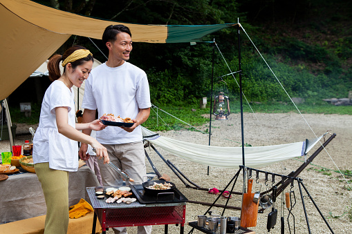 Couple Cooking Food On BBQ