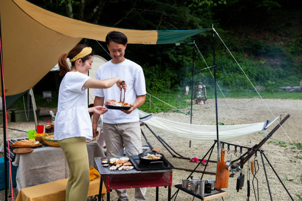 istock Young couple barbecuing at a campsite 1417834505