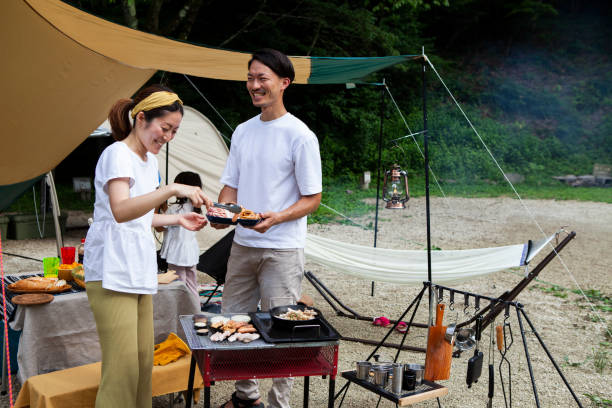 istock Young couple barbecuing at a campsite 1417834513