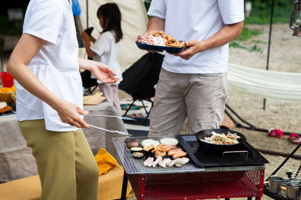 istock Young couple barbecuing at a campsite 1417834514