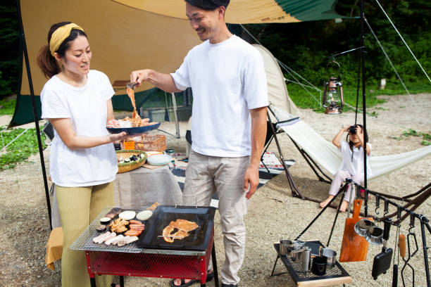 istock Young couple barbecuing at a campsite 1417834516