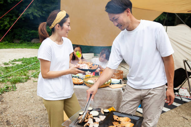 istock Young couple barbecuing at a campsite 1417834528