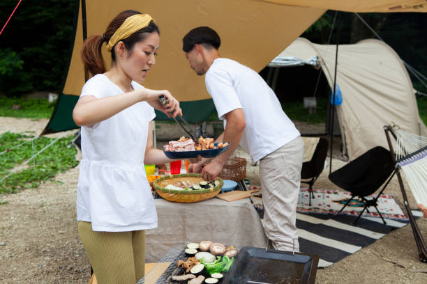 istock Young couple barbecuing at a campsite 1417834534