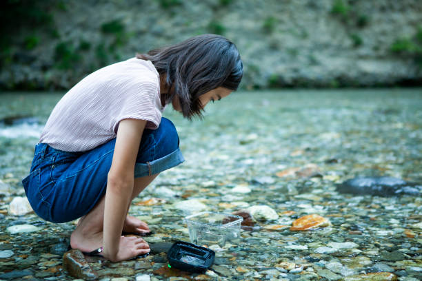 istock A girl at camping site looks into river water 1417834725