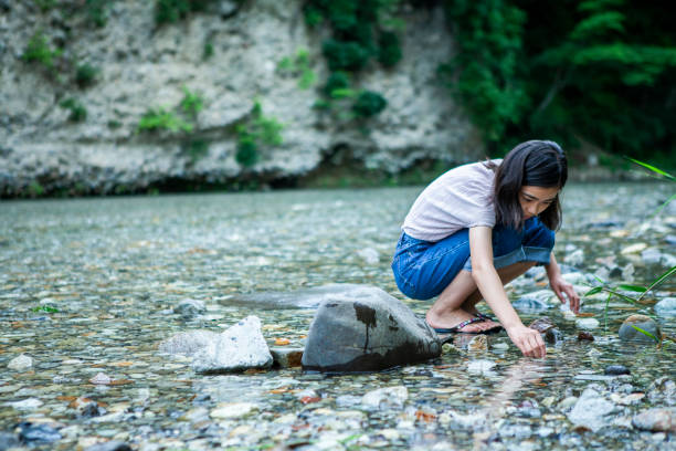 istock A girl at camping site looks into river water 1417834746