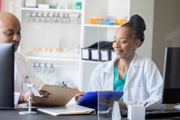 istock Two pharmacists engaging in conservations about new products. 1417836409