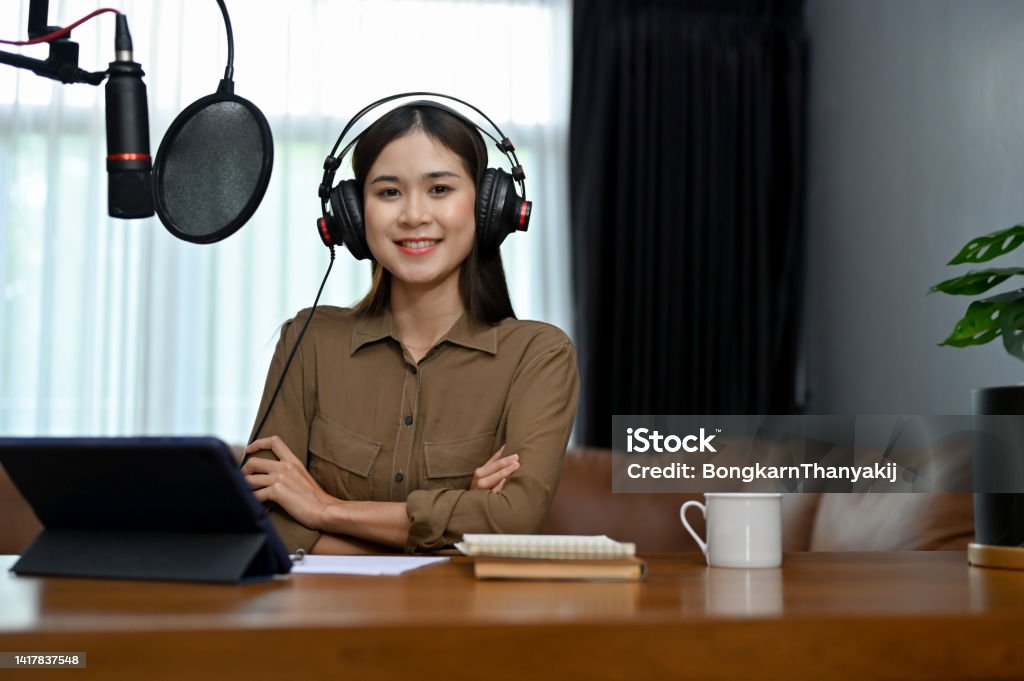 Talented Asian female blogger podcaster in her home studio, using recording equipment Professional and talented young Asian female blogger podcaster in her home studio, using recording equipment to running her online radio show. 20-24 Years Stock Photo