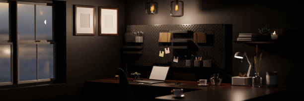 moderno estiloso espaço de trabalho de escritório escuro à noite com mockup laptop na mesa preta, parede preta. - warm light - fotografias e filmes do acervo