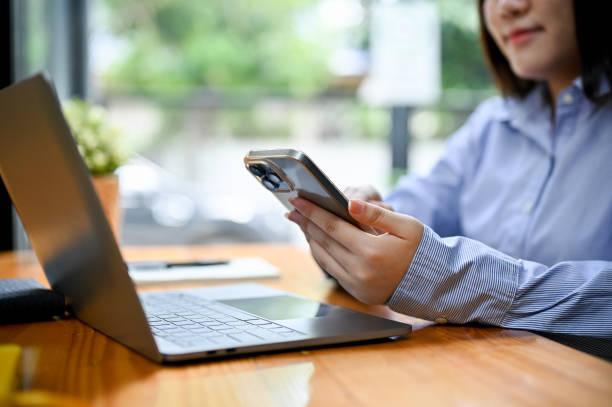 istock close-up. Businesswoman using her smartphone while working at her office 1417839697
