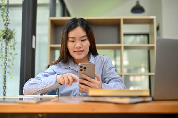 istock Asian female office worker employee using her smartphone at her office desk. 1417839704
