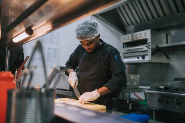 istock Asian Indian Kitchen crew helper cutting onion preparing food 1417840011