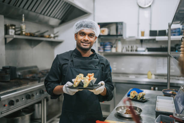Asian indian Kitchen male crew helper looking at camera smiling