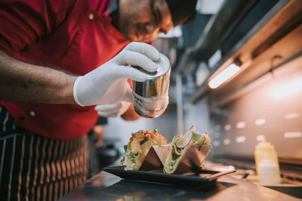 Asian Indian Chef preparing taco Mexican food in kitchen