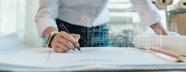 Architect or Engineer hand writing detail on blueprint architecture.