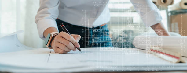 Architect or Engineer hand writing detail on blueprint architecture. stock photo