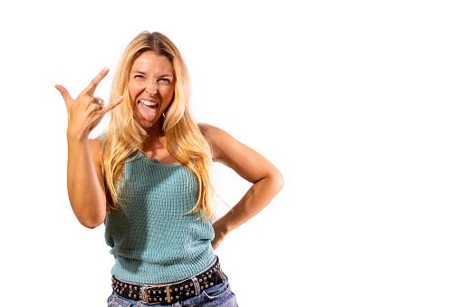 Motivated and smiling rocker girl raises her fingers in rocker sign.