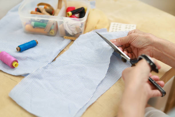 Senior woman working on fabric at home stock photo