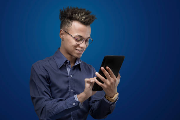 istock Adult man using digital tablet in photo studio with blue background 1417851395