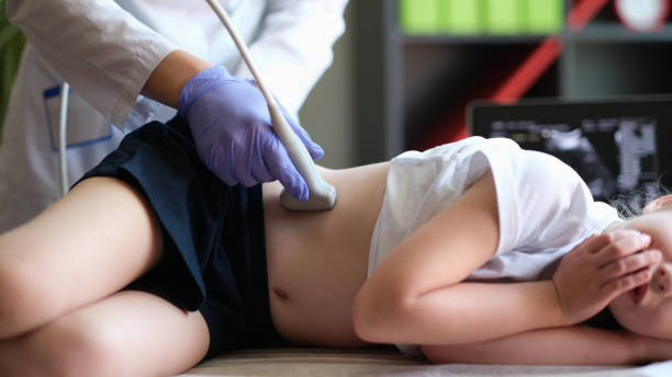Doctor conducting ultrasound examination of kidneys to child in clinic Doctor conducting ultrasound examination of kidneys to child in clinic. Diagnosis of pyelonephritis in children concept urinary system stock pictures, royalty-free photos & images