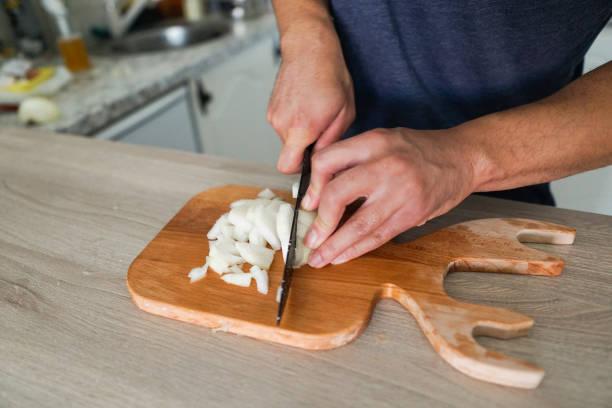 istock Man cutting or chopping onion, preparing onions for a meal 1417853347