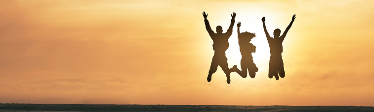 Group of happy friends having fun and jumping in the beach at sunset - Young people celebrating success outdoor - People, success and travel concept