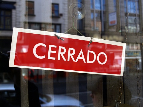 Closed sign in a shop window written in Spanish (translation: Closed)