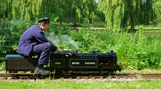 St Neots, Cambridgeshire, England -  May 05, 2022: Miniature Steam train  and driver in the park.