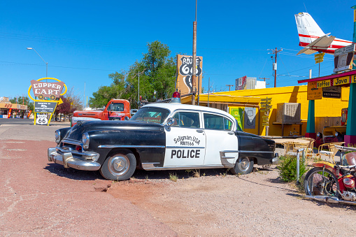 Seligman, USA - May 25, 2022: vintage historic police car at a shop and a route 66 souvenir shop in Seligman, USA.