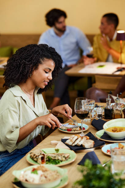 istock Hispanic young woman eats dinner in a restaurant. 1417858371