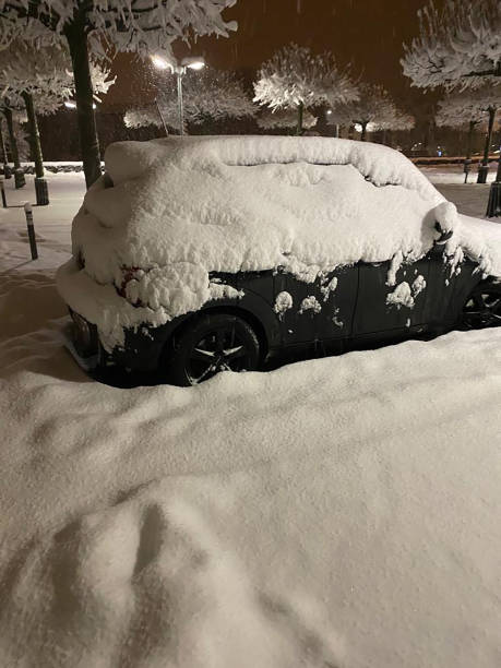 istock Rear view black car covered snow trees background 1417859477